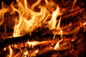 Closeup burning firewood in the stove on black background